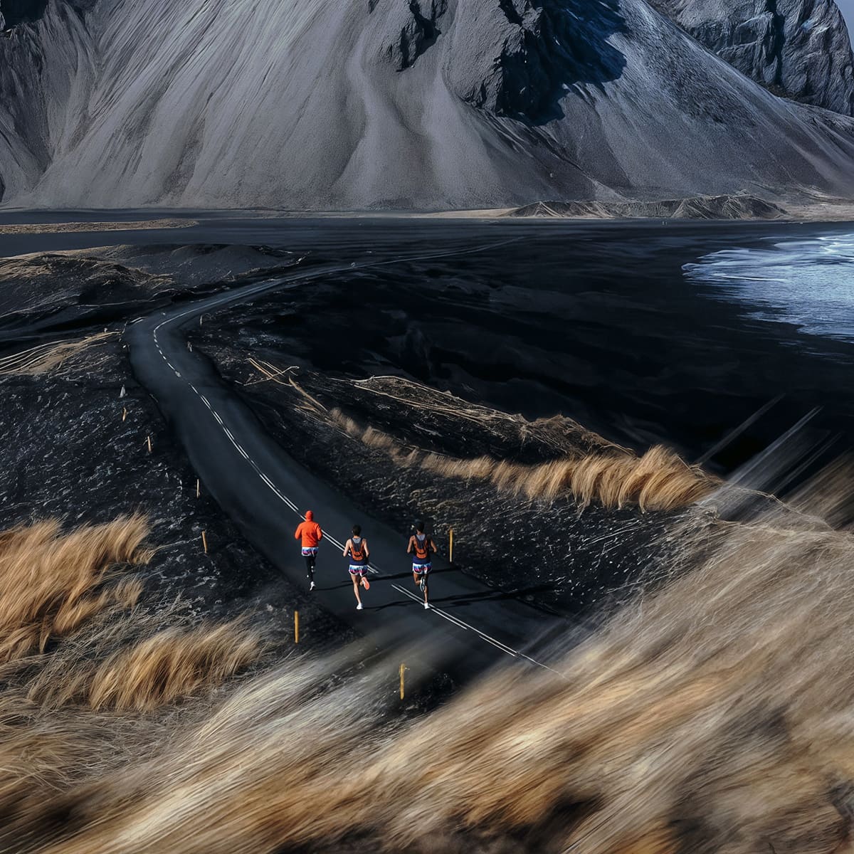 Three runners on a winding road through a dramatic mountain landscape