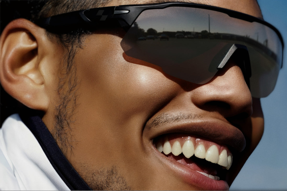 Close-up of a person wearing reflective sunglasses with a blurred background