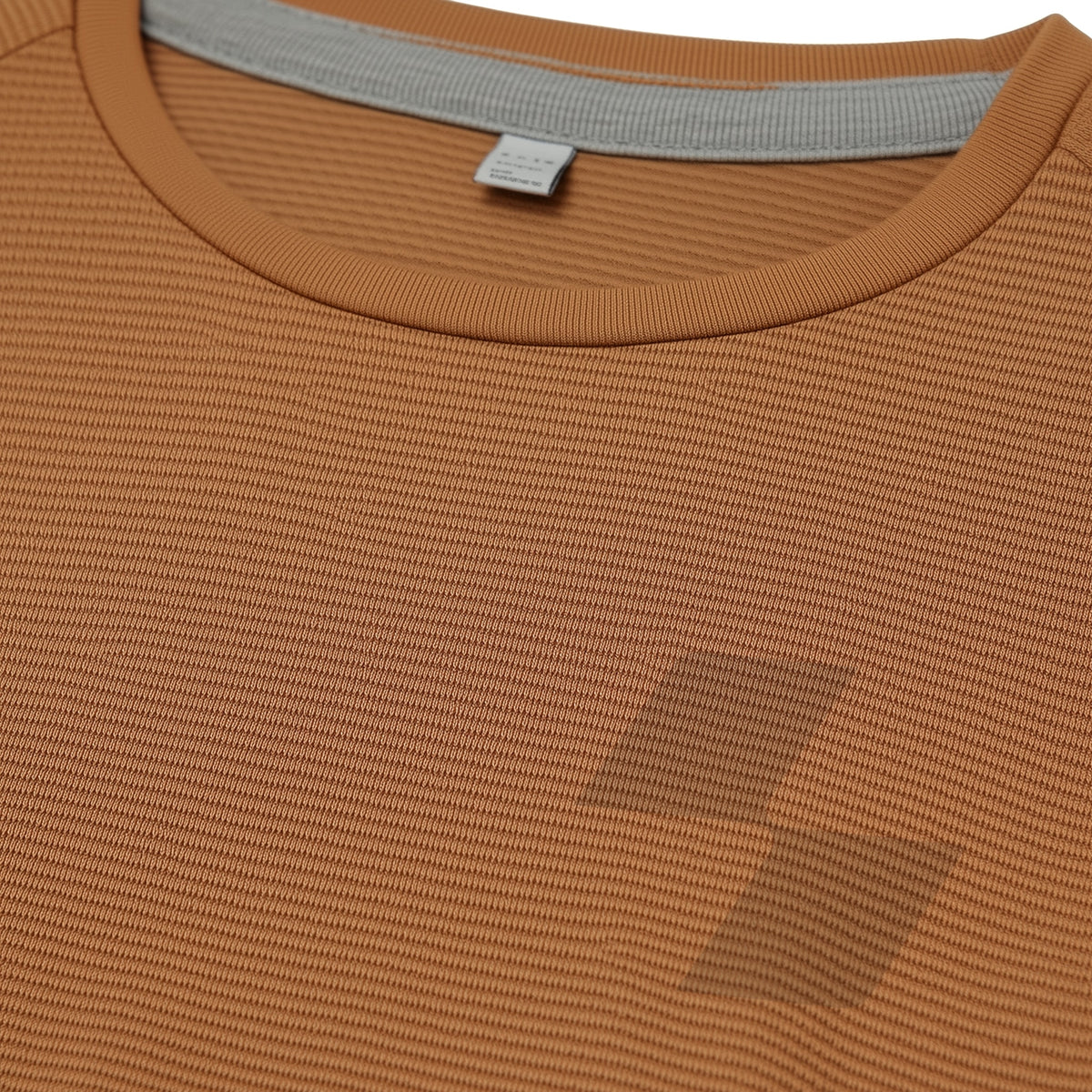 Close-up of a brown textured shirt with a collar and tag (Beige)
