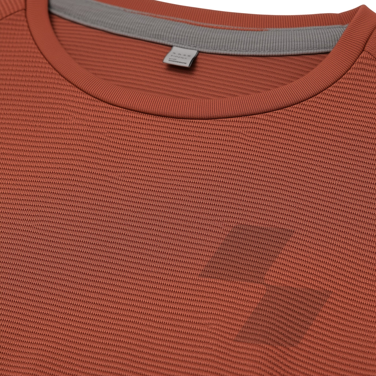 Close-up of a textured orange shirt with a brand tag (Orange)