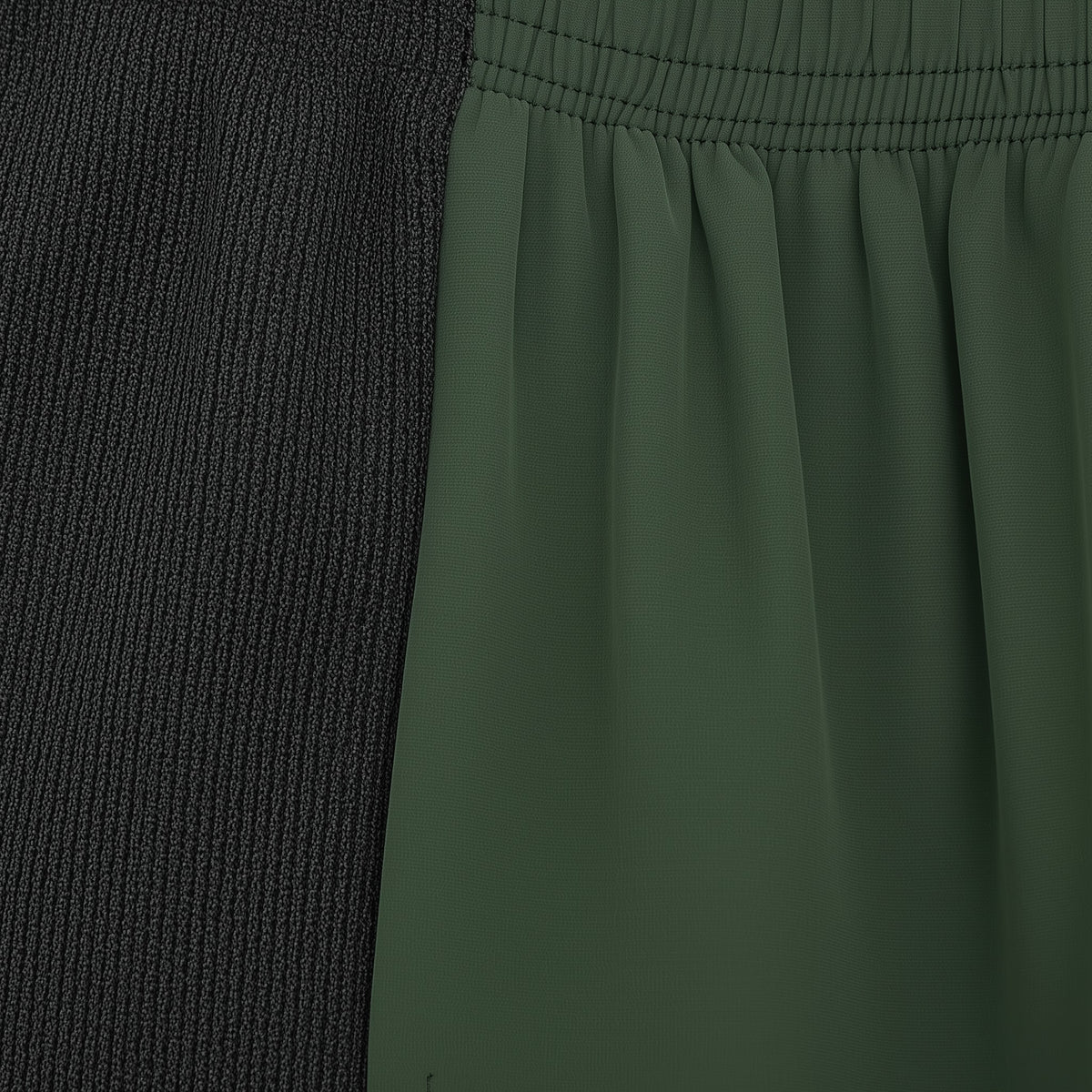 Close-up of a green fabric with a textured black section on the left. (Green)