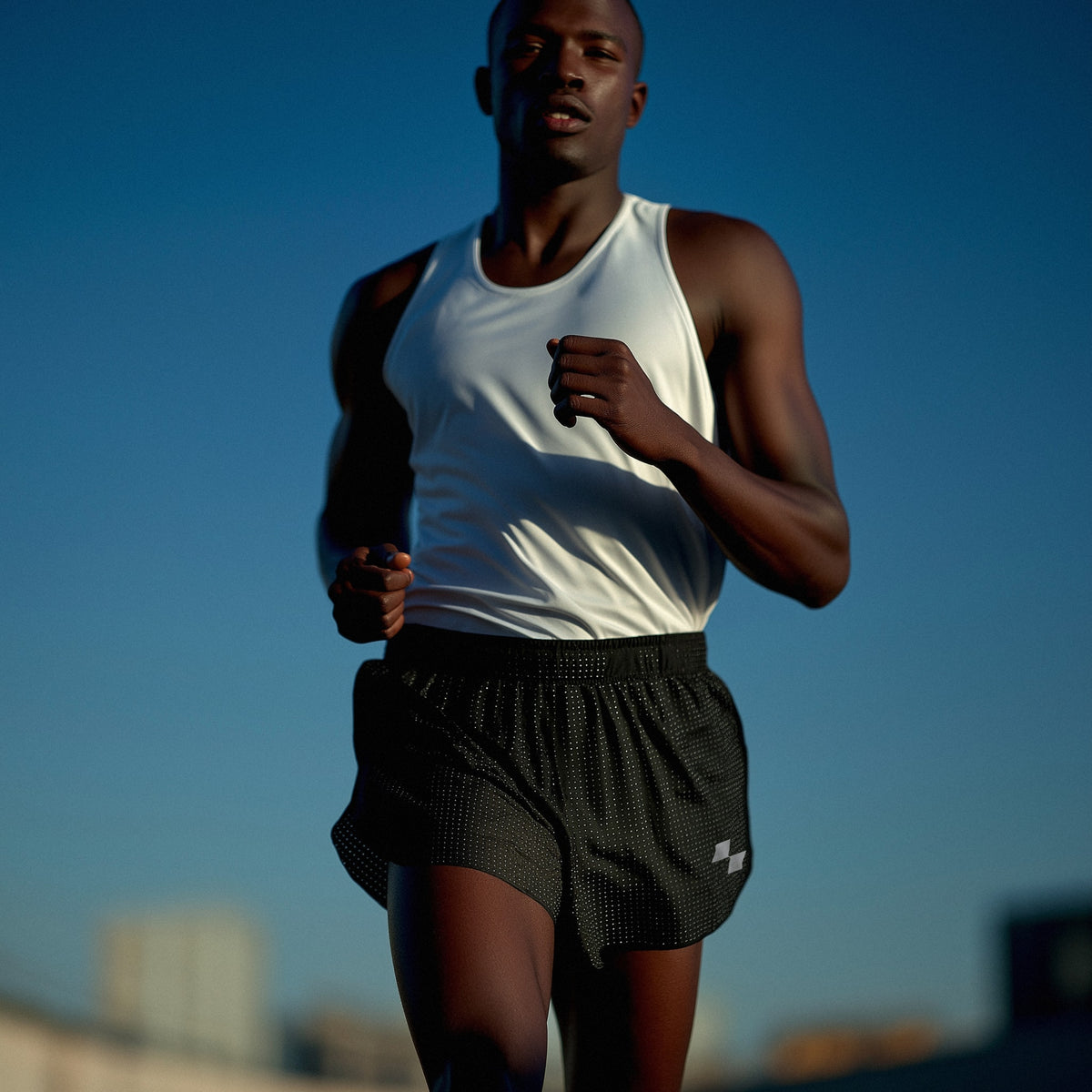 Man running outdoors with a clear blue sky in the background (Black)