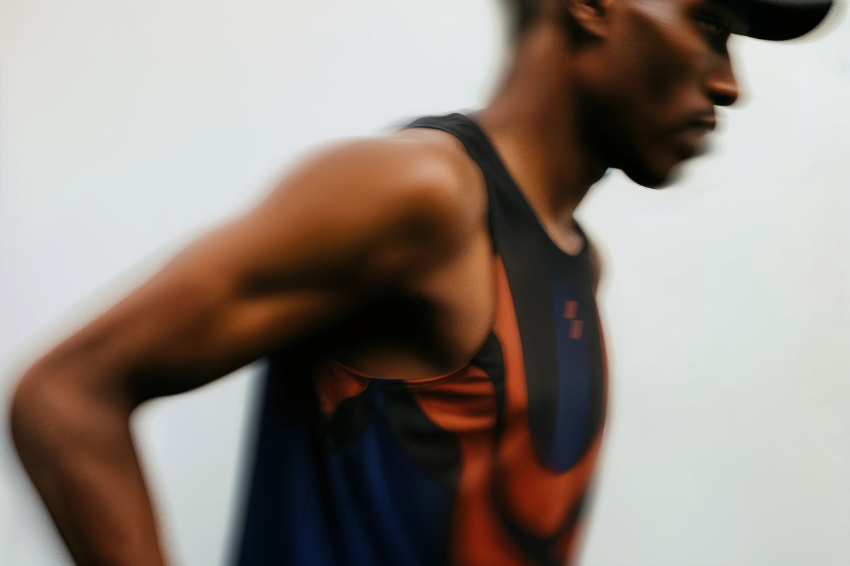 Blurred image of a person wearing a tank top with a colorful design.